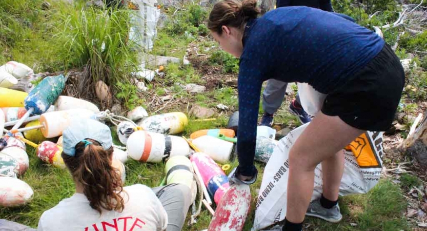 Two people gather buoys as part of a service project. 